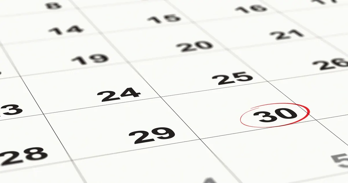 A close-up of a paper wall calendar with the number 30 circled in red pen