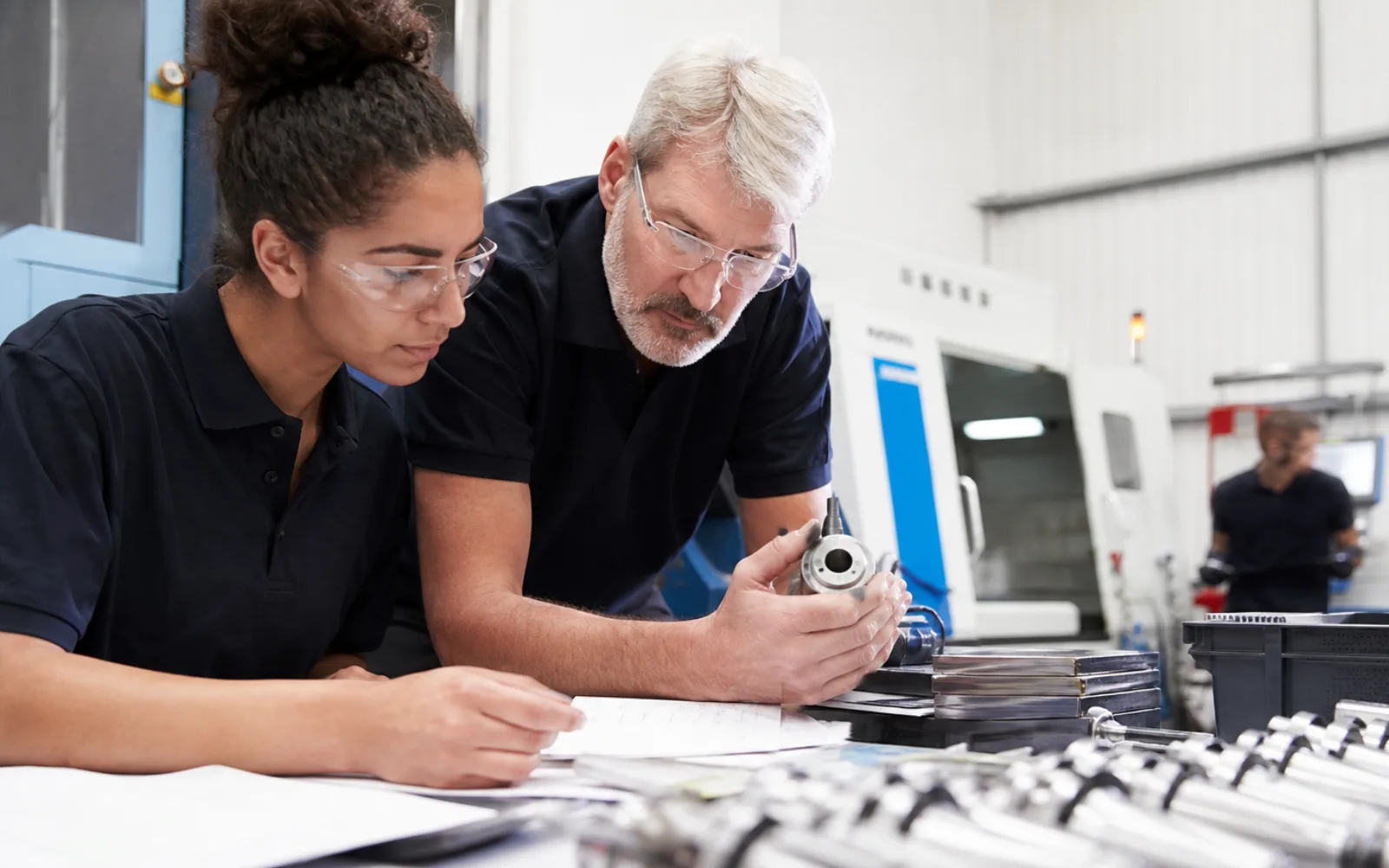 UK manufacturing team reviewing live production data beside connected machinery