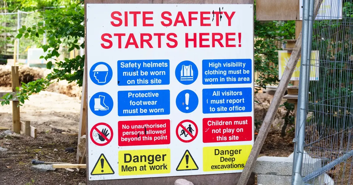 A construction site safety board headed 'Site safety starts here' with rows of helmet, hi-vis and danger signs