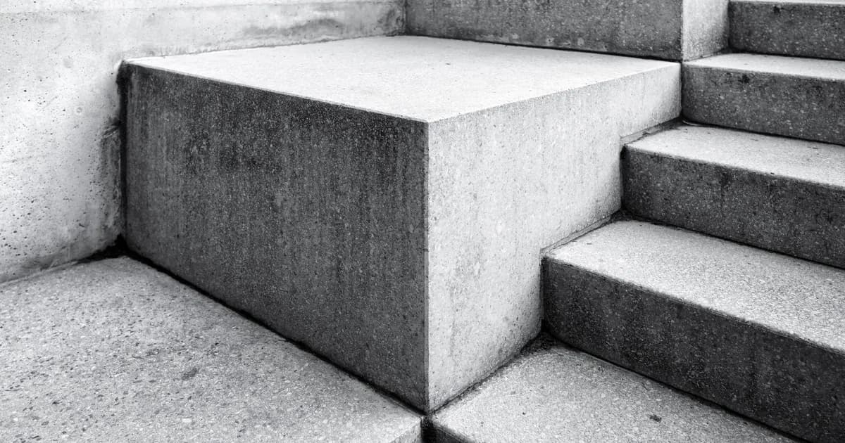 Plain concrete steps and a blank landing block photographed close up in black and white