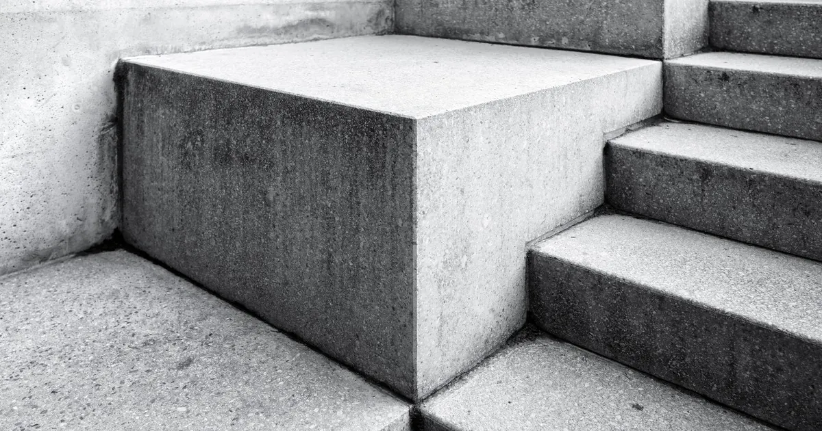 Plain concrete steps and a blank landing block photographed close up in black and white
