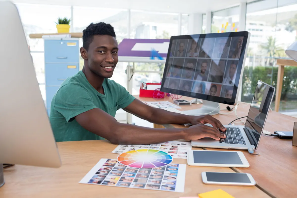 Designer reviewing a website on a desktop computer beside colour samples